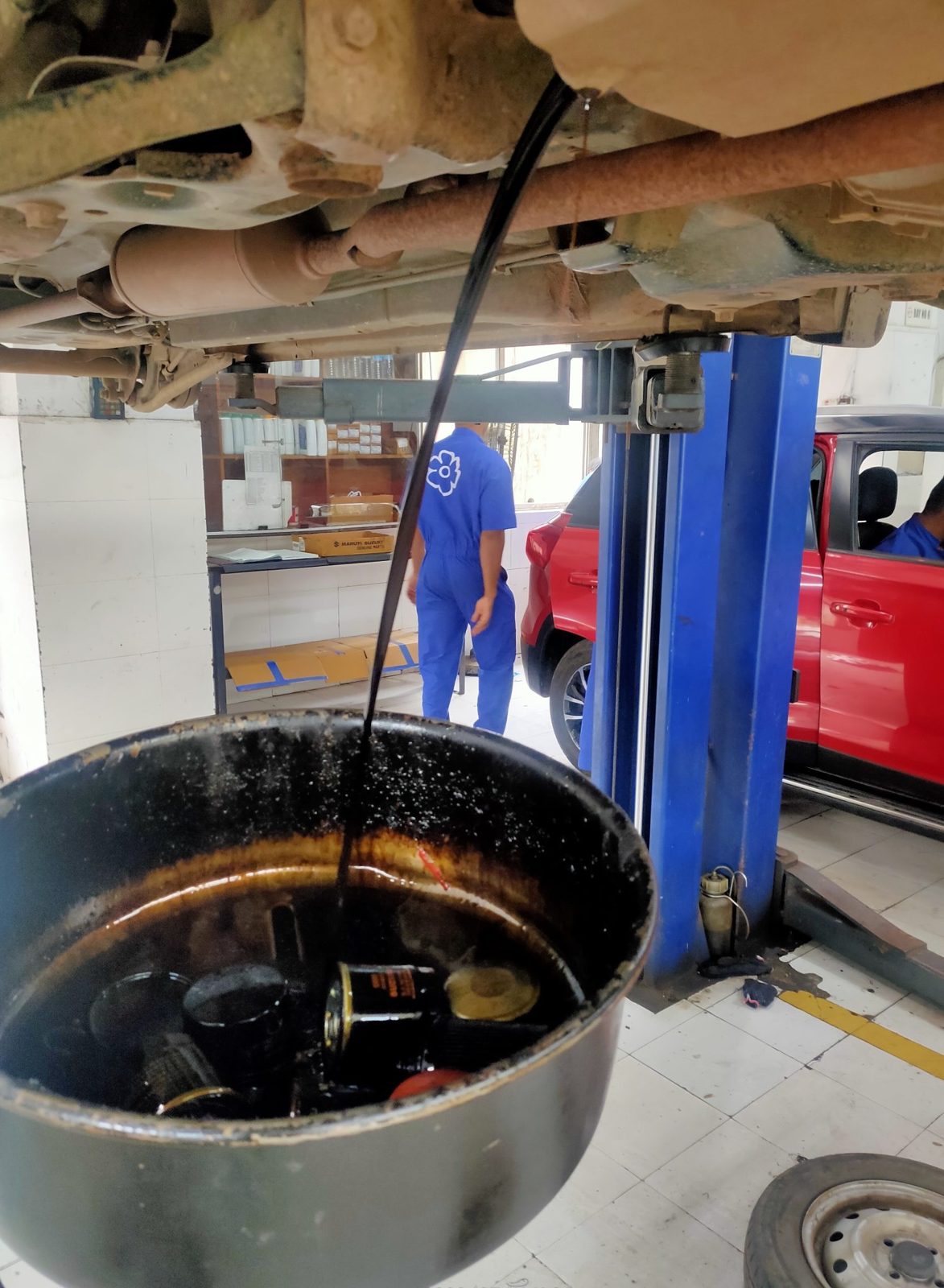 Used oil draining from a car on a hoist